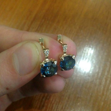 женские серьги с большими камнями в руке