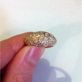 широкое кольцо с маленькими камнями в красном золоте в руке