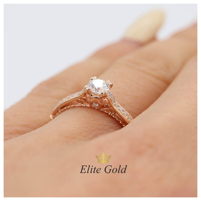 женское кольцо с узорами в белом золоте, зеленым камнем и фианитами
